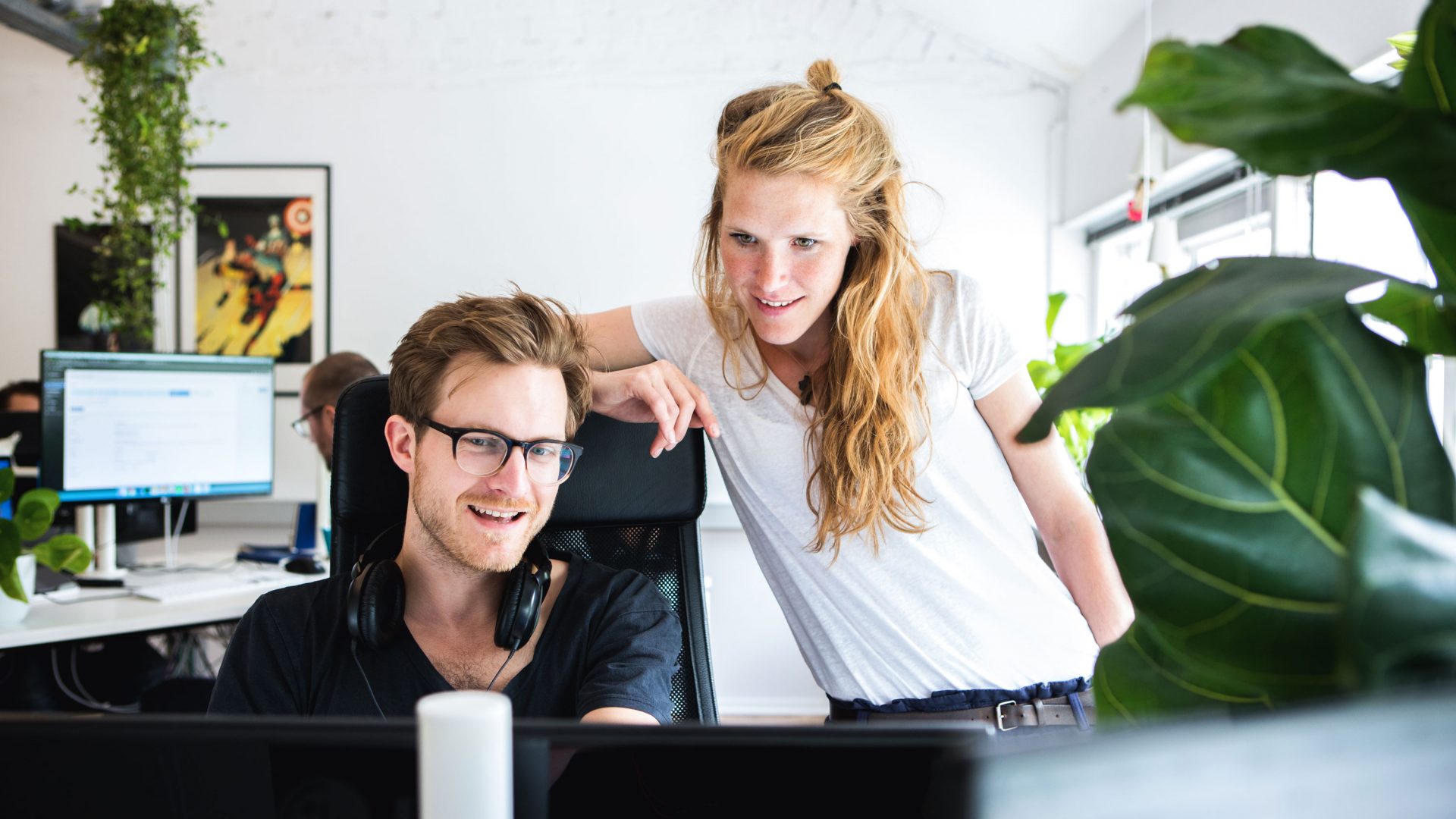 Werknemers van September die naar een scherm kijken en samenwerken